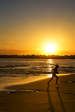 Silhouette Of A Child Running On A Beach At Sunset, Caloundra, Queensland, Australia