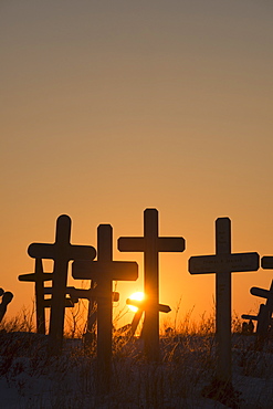 A Setting Sun Shines Through Crosses At Cemetery Hill In Kotzebue, Alaska.