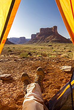 View Of A Camper's Feet Out Of A Tent Viewing Rock Cliffs, Canyonlands National Park, Utah, United States Of America