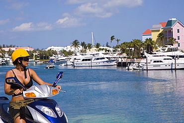 Mid adult woman driving a moped, Paradise Island, Bahamas