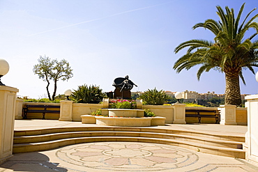 Palm tree and a statue in a garden, Monte Carlo, Monaco