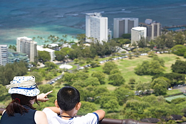 Rear view of a boy and a girl looking at a city from an observation point, Diamond Head, Waikiki Beach, Honolulu, Oahu, Hawaii Islands, USA