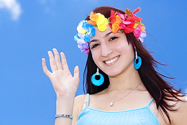 Portrait of a young woman wearing flowers and waving her hand