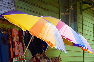 Three umbrellas with clothes in a clothing store, Coxen Hole, Roatan, Bay Islands, Honduras