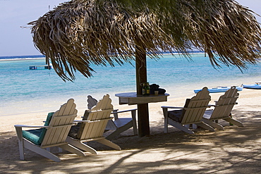 Beach chairs under palapa on the beach, Coral Cay, Dixon Cove, Roatan, Bay Islands, Honduras