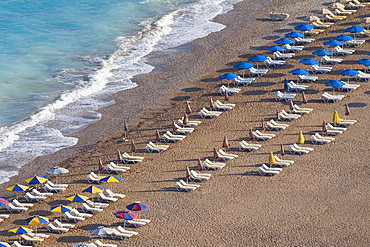 High angle view of beach umbrellas and lounge chairs on the beach, Rhodes, Dodecanese Islands, Greece