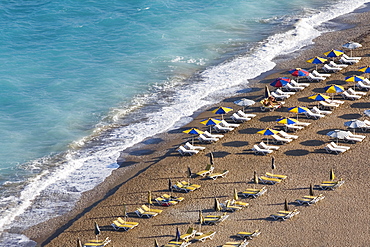 High angle view of beach umbrellas and lounge chairs on the beach, Greece