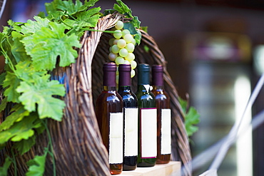 Close-up of four bottles of wine with a bunch of grapes, Greece