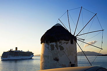 Traditional windmill on the coast with a cruise ship in the background, Mykonos, Cyclades Islands, Greece