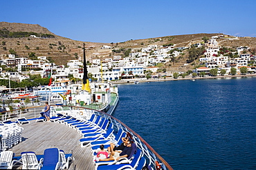 High angle view of tourists resting on lounge chairs on the deck of a ship, Skala, Patmos, Dodecanese Islands, Greece