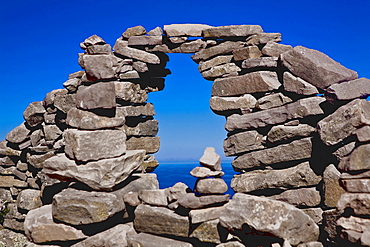 Lake viewed through a stone wall, Lake Titicaca, Taquile Island, Puno, Peru