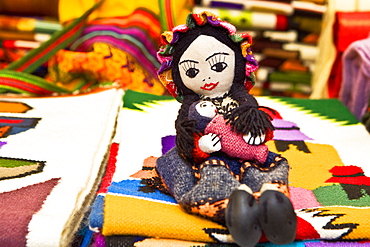 Doll and carpets in a market stall, Pisaq, Cuzco, Peru