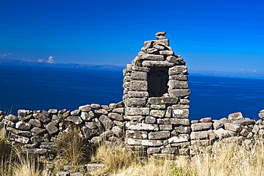 Old ruins of a stone wall at a lakeside, Lake Titicaca, Taquile Island, Puno, Peru