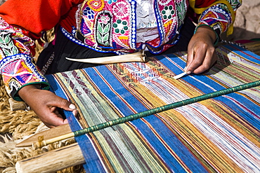 Mid section view of a woman weaving in a loom, Aguanacancha, Peru