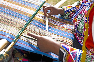 Mid section view of a woman weaving in a loom, Aguanacancha, Peru