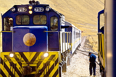 Rear view of a man walking near a train, Puno, Cuzco, Peru