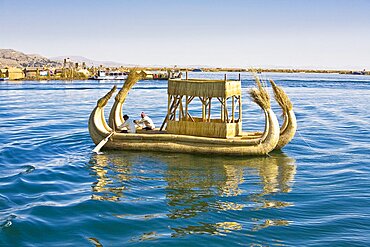 Two men rowing a reed boat, Lake Titicaca, Uros Floating Islands, Puno, Peru