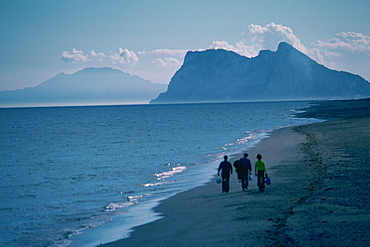 Three people walking on the beach, Rock of Gibraltar, Gibraltar, Spain