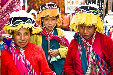 Portrait of three girls in a market, Pisaq, Urubamba Valley, Peru