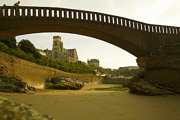 Arch bridge on the beach and a cathedral in the background, Port Des Pecheurs, Eglise Sainte Eugenie, Biarritz, France