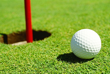 Close-up of a golf ball near a hole