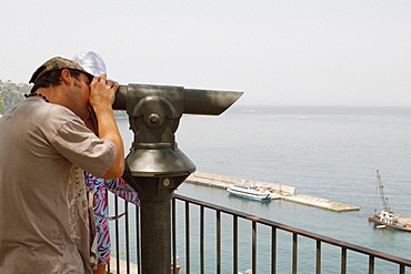 Side profile of a man looking through a coin-operated binocular, Bay of Naples, Via Aniello Califano, Sorrento, Sorrentine Peninsula, Naples Province, Campania, Italy