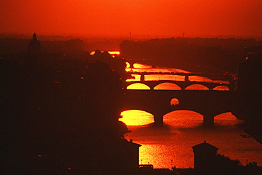 Silhouette of an arch bridge across a river, Ponte Vecchio, Arno River, Florence, Tuscany, Italy