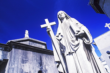 Low angle view of a statue of Virgin Mary with a cross