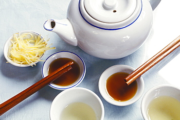 High angle view of a teapot with tea in bowls and chopsticks