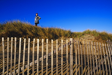 Low angle view of a woman standing on top of a hill, Cape Cod, Massachusetts, USA 