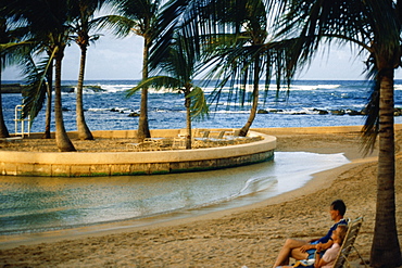 A couple is seen relaxing on a beach, Caribe Hilton, Puerto Rico