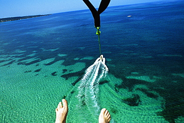 A mans feet are seen as he parasail over Negril Beach, Jamaica