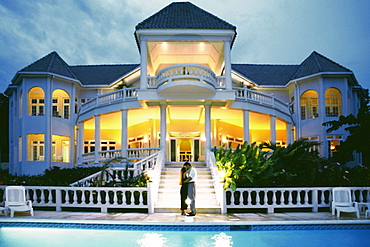 A couple kiss in front of the illuminated Endless Summer Villa, Jamaica