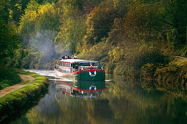 Side view of a luxury barge moving upstream, France