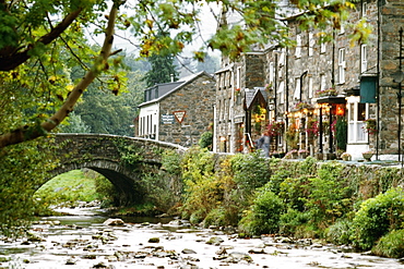 Side view of a stone bridge and shops in Beddgeurant, Wales