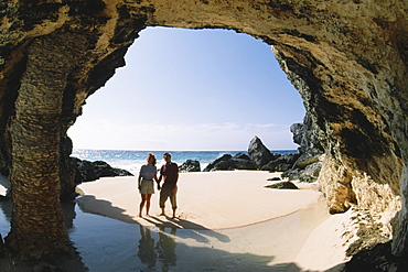 A couple observing rocks near the ocean, Natural arch, Bermuda