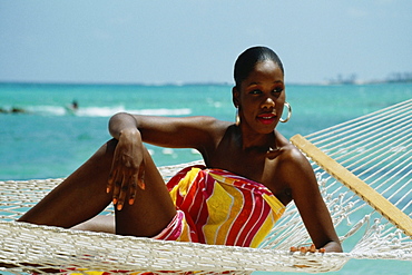 Front view of a woman relaxing in a hammock at Crystal Palace Hotel, Nassau, Bahamas