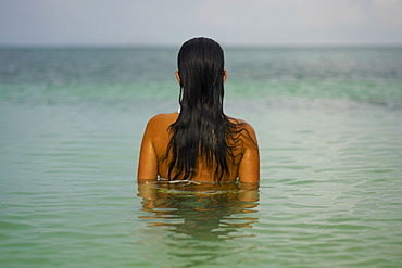 Rear view of a young woman in the water