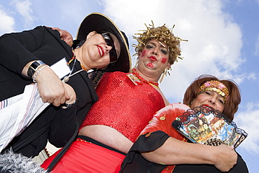 Low angle view of a mature man with two mature women wearing costumes