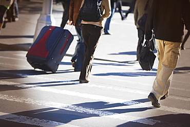 Low section view of men and women walking on the road