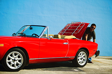 Mid adult man standing behind a convertible car, Miami, Florida, USA