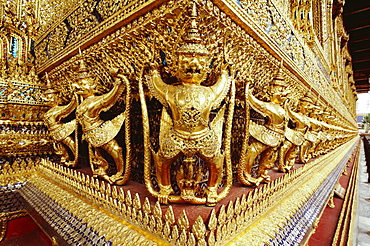 Golden statues carved on walls of a temple, Wat Phra Kaeo, Bangkok, Thailand