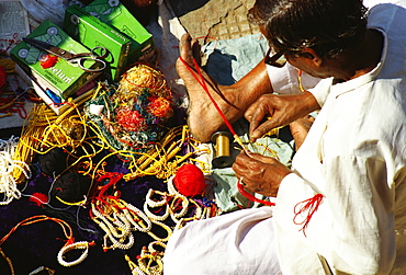 High angle view of a mature man making bracelets, Jaipur, Rajasthan, India