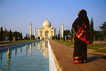 Rear view of a woman standing in front of a mausoleum, Taj Mahal, Agra, Uttar Pradesh, India