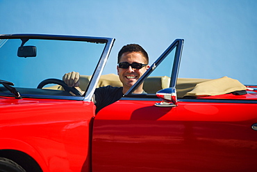 Mid adult man sitting in a convertible car, Miami, Florida, USA