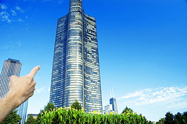 Close-up of a human hand pointing to a building, Lake Point Tower, Chicago, Illinois, USA