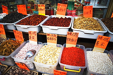 Close-up of tubs of spices with dry fruits and dry fishes