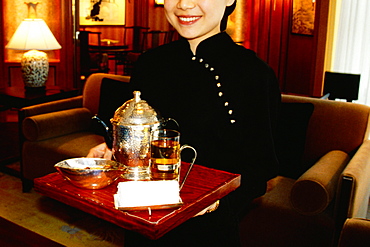 Waitress holding a serving tray and smiling, Shanghai, China