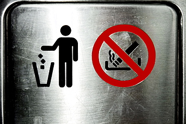 Close-up of Trash and No Smoking sign on a metal door