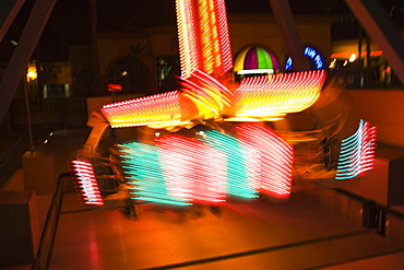 Lights glowing on a carnival ride at night, California, USA